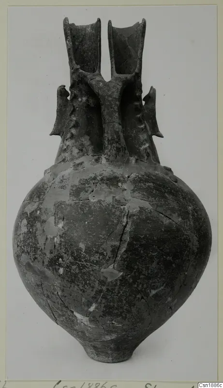 Pottery vessel, Red Polished I, with a round body and two tall flaring spouts joined by a bridge-like handle