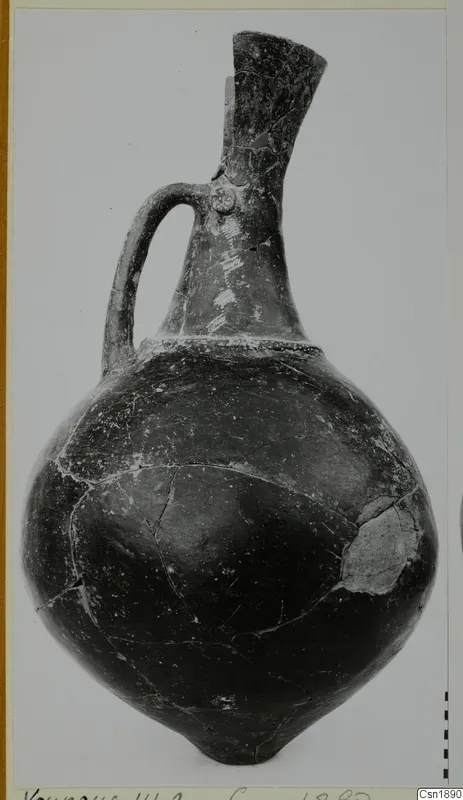 Black-polished jug with a tall flaring neck and a single loop handle, from Vounous.