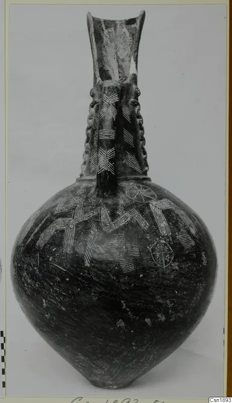 Dark-surfaced vessel with a tall flaring neck, two handles and incised zigzag and circle patterns on the body