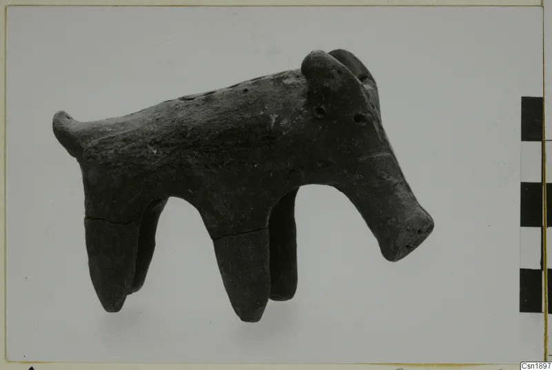 Dark clay animal figure with four tapering legs, a long snout and a short tail, from Vounous.
