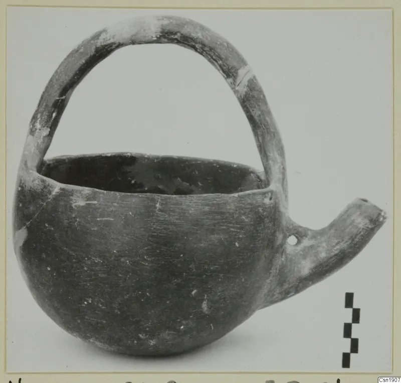 Pottery Red Polished I vessel from Vounous with a strap handle and a side spout