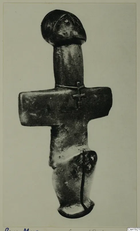 Dark metal-looking figurine from Petra tou Limniti with a rounded head and a horizontal bar across the body