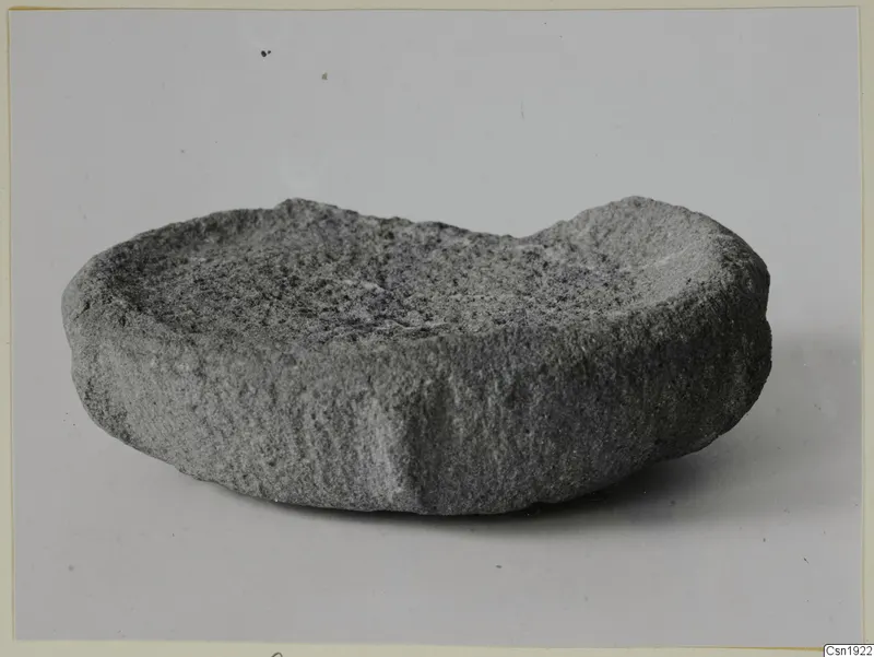 Stone fragment from Petra Tou Limniti: a shallow, crescent-shaped worked stone dish with a rough grey surface.