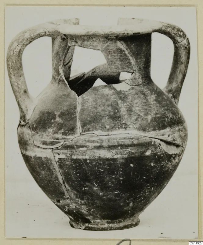 Two-handled jar with a broken neck and shoulder, photographed against a pale background