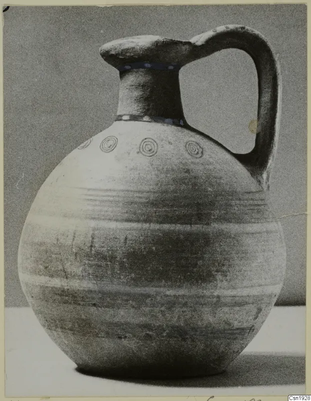 Bichrome-Red pottery jug from Marion with a round body, tall neck and strap handle, against a grey backdrop
