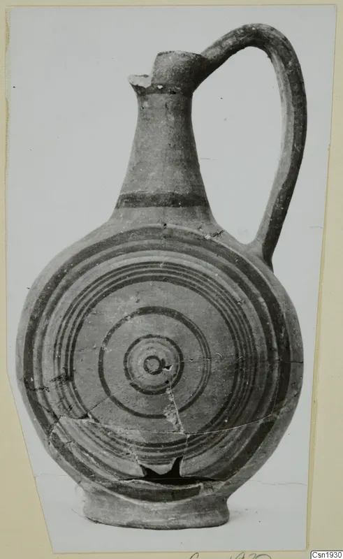 Painted pottery jug with a single loop handle and concentric rings on its rounded body