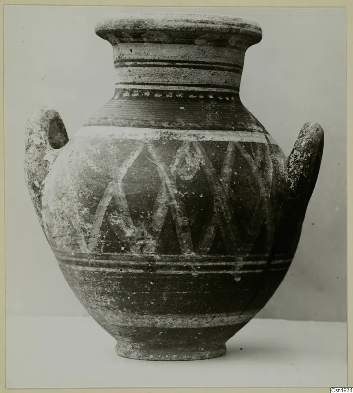 Two-handled painted pottery jar with a pale diagonal lattice pattern and horizontal bands, photographed against a grey backdrop