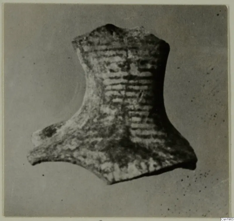 Pottery fragment with horizontal ridged bands, photographed against a grey background