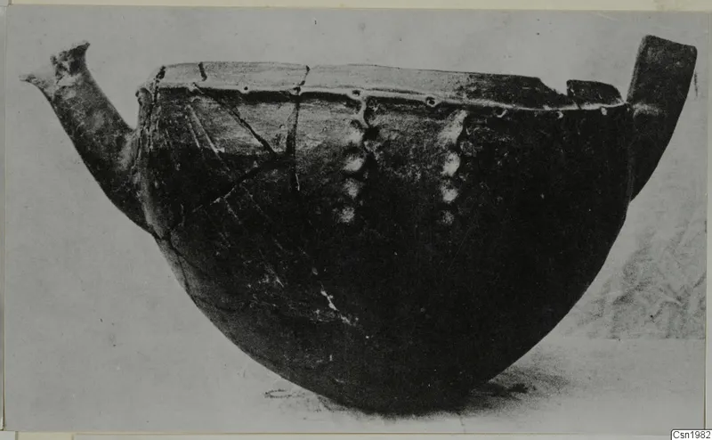 Red Polished III bowl with a spout-like projection on the left and a handle-like projection on the right, seen from the side.
