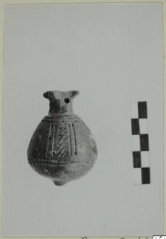 Small globular pottery vessel with a short neck, rim projections and incised lines on the body, beside a scale bar.