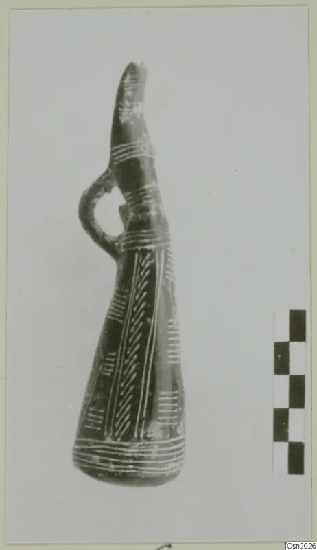 Dark pottery vessel with a tall neck, side loop handle and white painted bands and herringbone pattern.