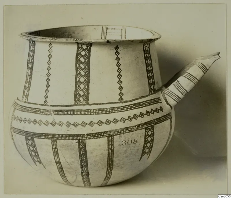 White Slip ware vessel with a tubular spout and dark brown painted bands and lattice panels