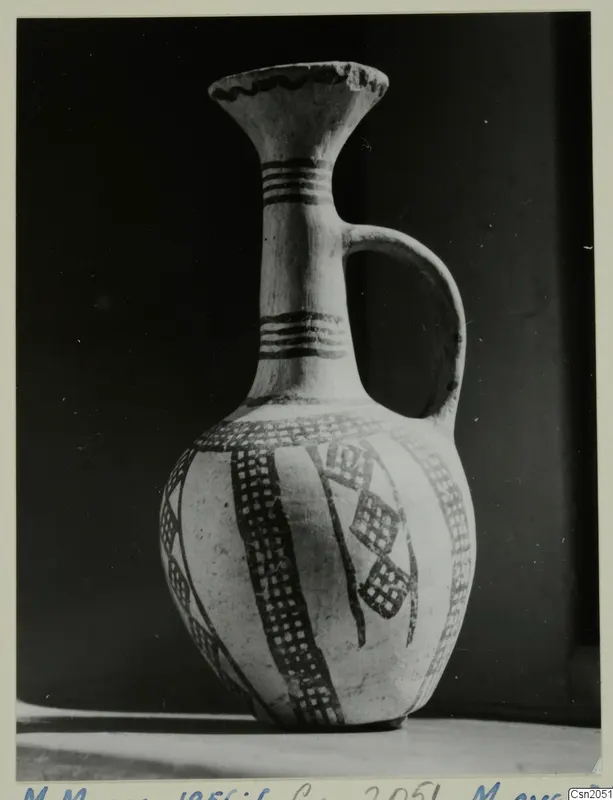 Pottery White Slip Ware jug with cross-hatched painted bands, photographed against a dark background