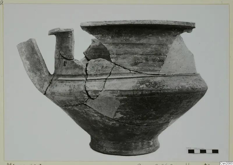Pottery Monochrome Ware vessel from Marion with a tubular spout and flaring rim, broken and partly pieced together.