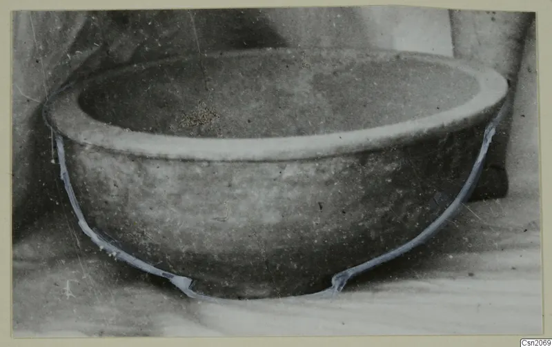 Bowl with a thick rim and rounded body, photographed on a pale surface, with blue lines tracing its outline
