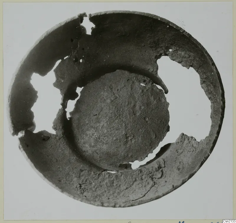 Broken bowl seen from above, with its rim missing in several places