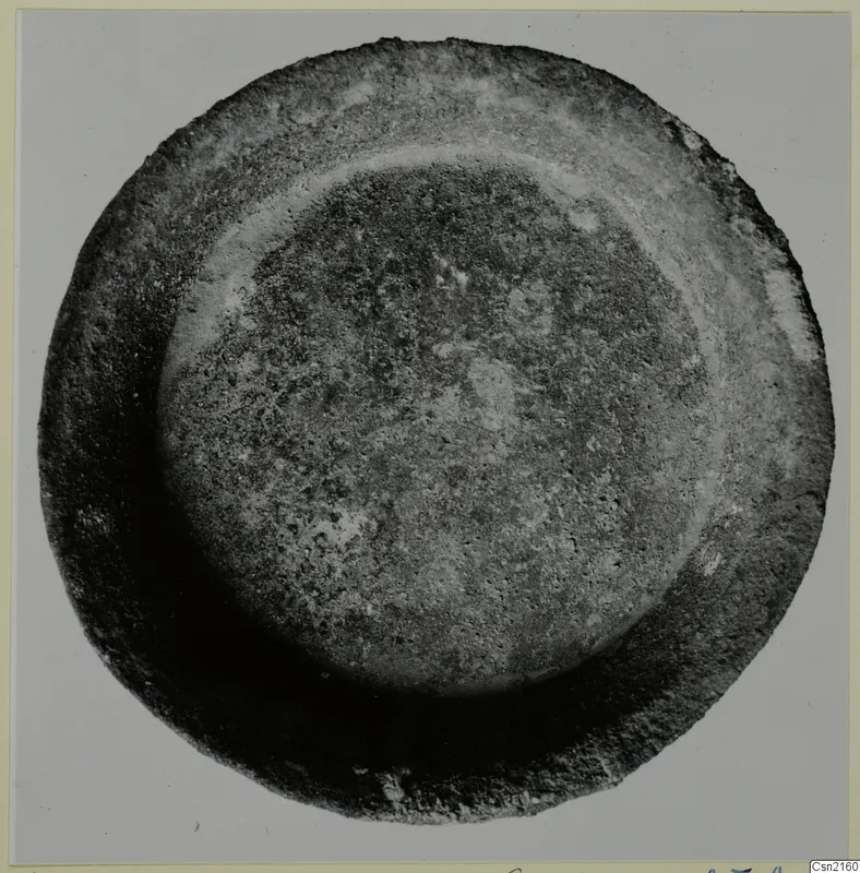 Shallow bowl seen from directly above, with a raised inner ridge and an encrusted surface
