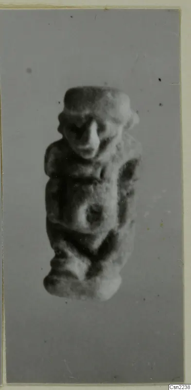 Small modelled figurine of a human figure with a broad head and prominent nose, shown alone