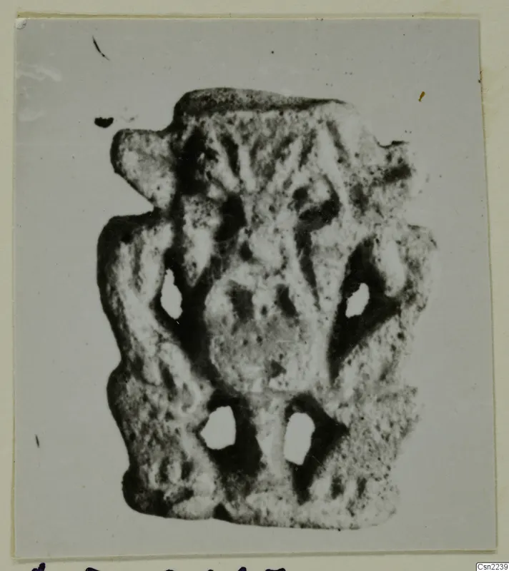 Small flat object with raised relief and four holes, photographed on a card mount, Ayia Irini finds