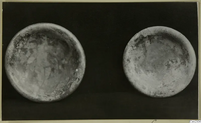 Two blown glass bowls seen from above against a dark background.