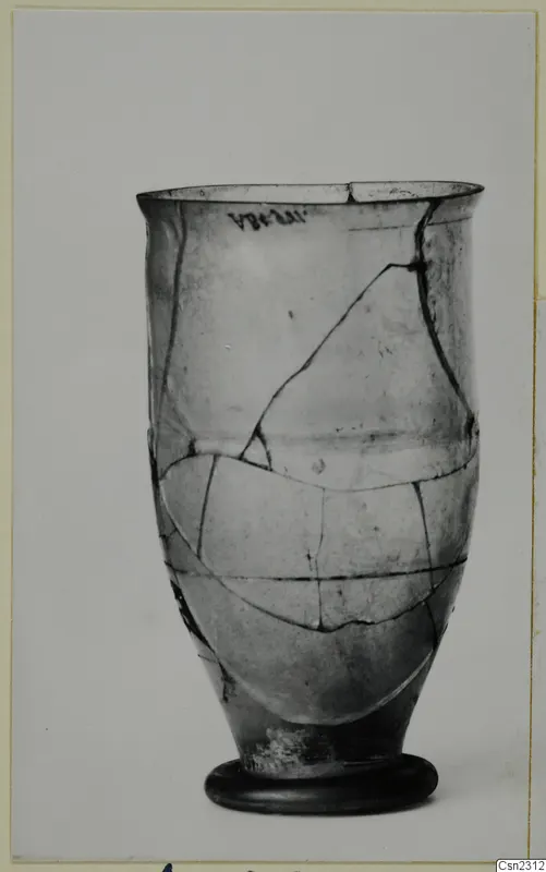 Blown glass vessel with a flared rim and ring foot, repaired from broken pieces