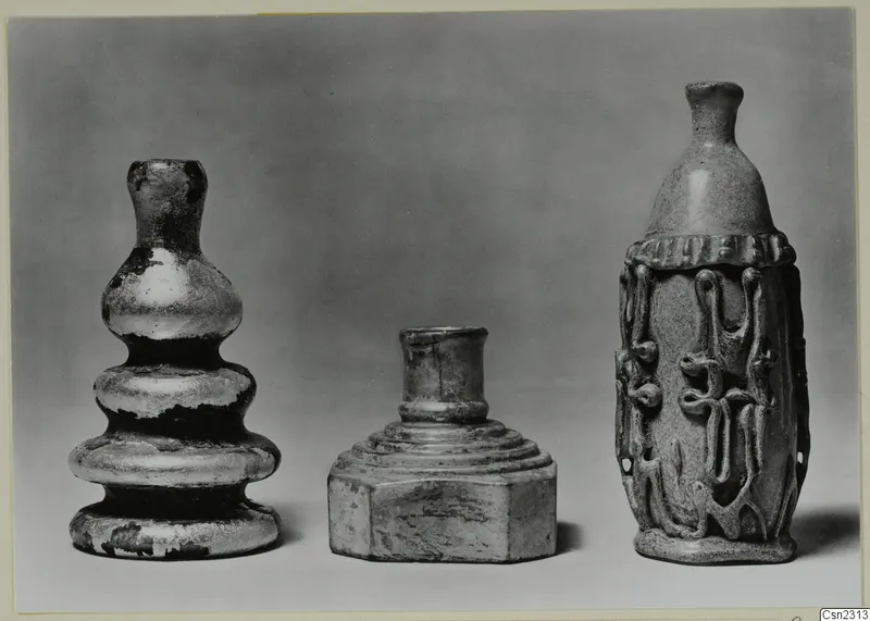 Three blown glass vessels of different shapes, the right one with trailed thread decoration