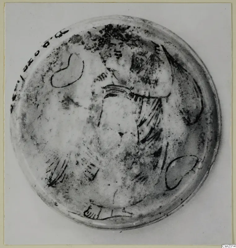 Shallow circular glass object seen from above, with dark painted lines forming a pattern across its surface