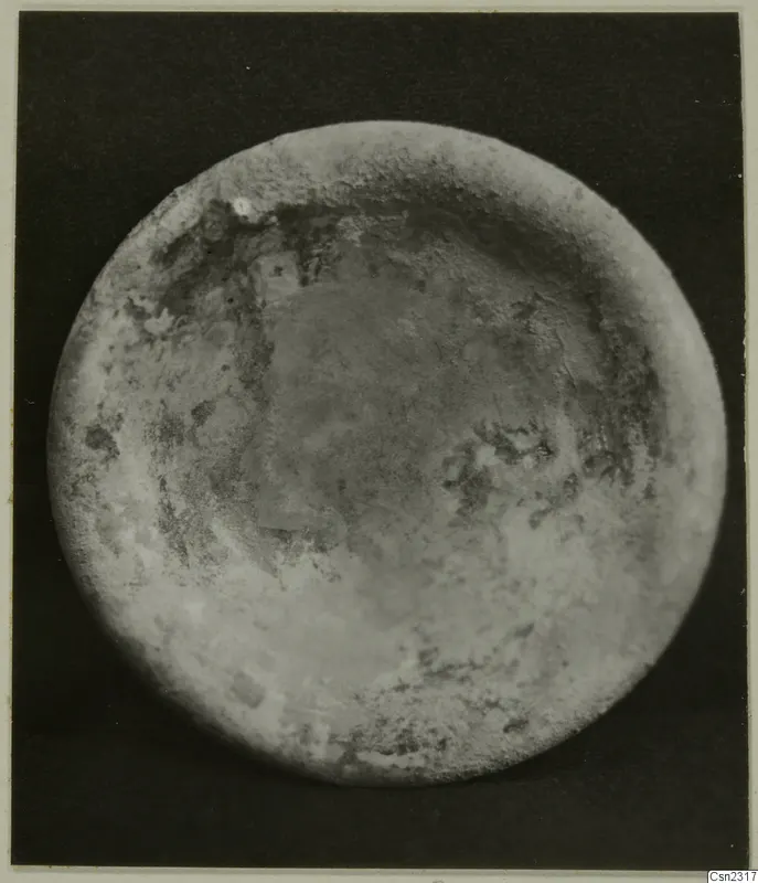 Blown glass object seen from above: a round piece with a raised rim and a weathered, mottled surface