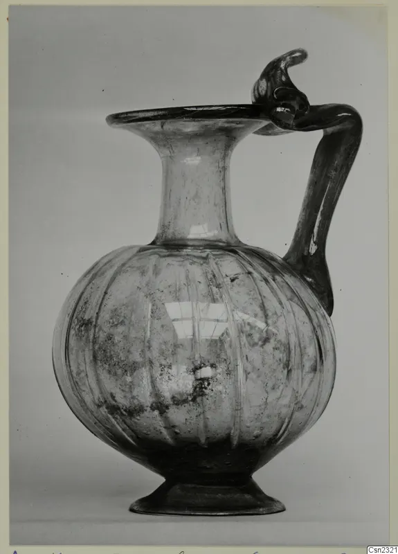 Blown glass jug with a ribbed globular body, flaring rim and twisted handle, from Amathus