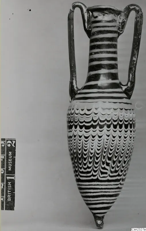 Sand-core glass two-handled vessel with white and dark trailed stripes and a feather-like pattern on the body.