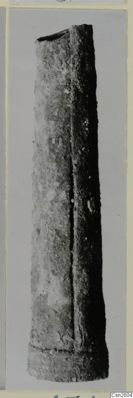 Bronze weapon: a long, tapering tubular metal object with an open top, photographed upright against a plain background