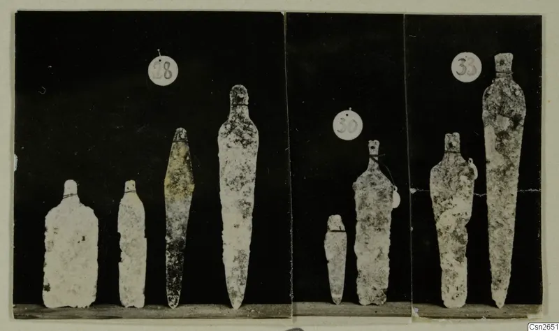 Eight metal blades with tangs, shown in three photographed groups, each with a round number label.