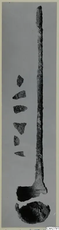 Bronze utensils: a long metal implement with a broad end, a bowl-shaped piece below, and small sherds beside it.