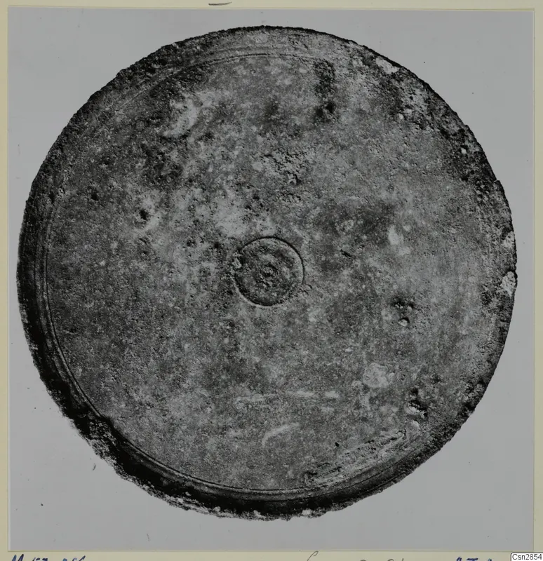 Bronze mirror from Marion, tombs 46–60, seen as a round disc with a central boss