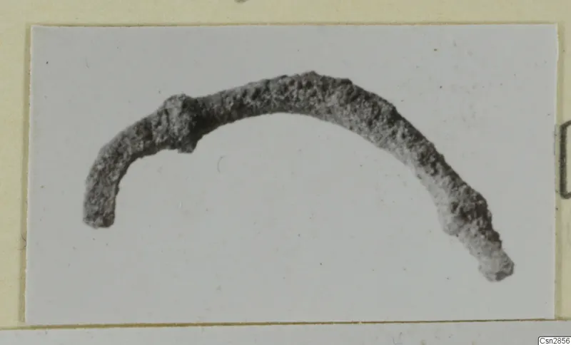 Corroded curved metal fragment, recorded as a bronze personal adornment, shown on a plain background.