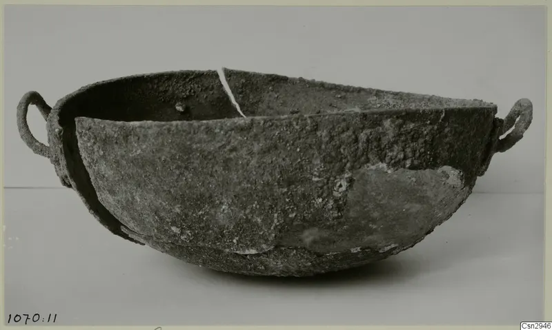 Heavily corroded bowl with two ring handles