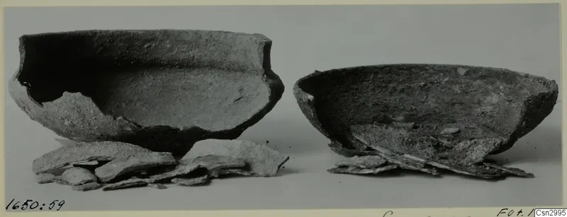Two broken bowls with loose sherds in front, photographed before conservation
