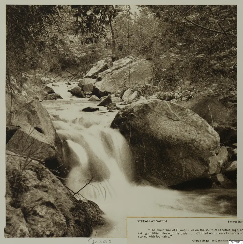 Stream cascading over large boulders at Saitta, with trees and dense foliage along the banks.