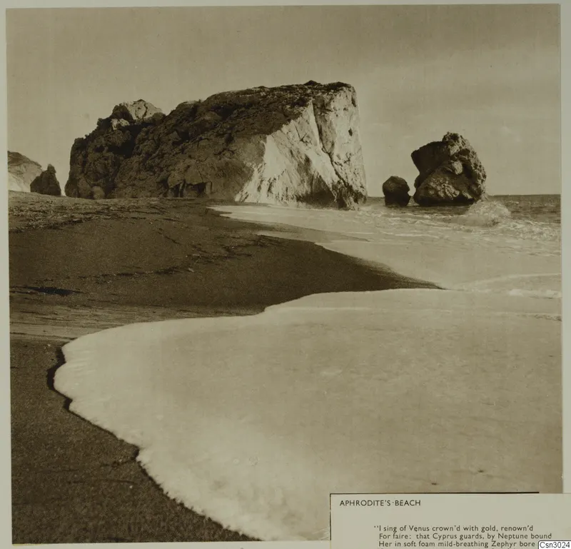 Aphrodite's Beach: a sandy shore with breaking surf, a large rock mass and offshore rock stacks in the sea