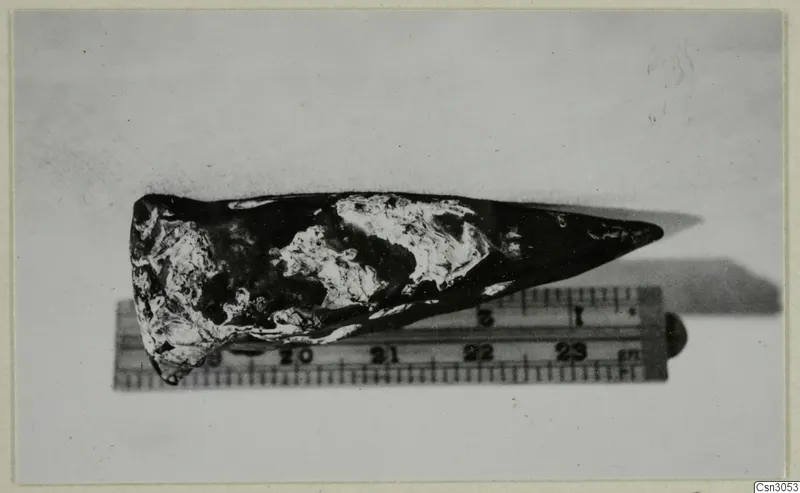 Iron moil, a pointed iron tool with corroded patches, lying beside a measuring ruler for scale
