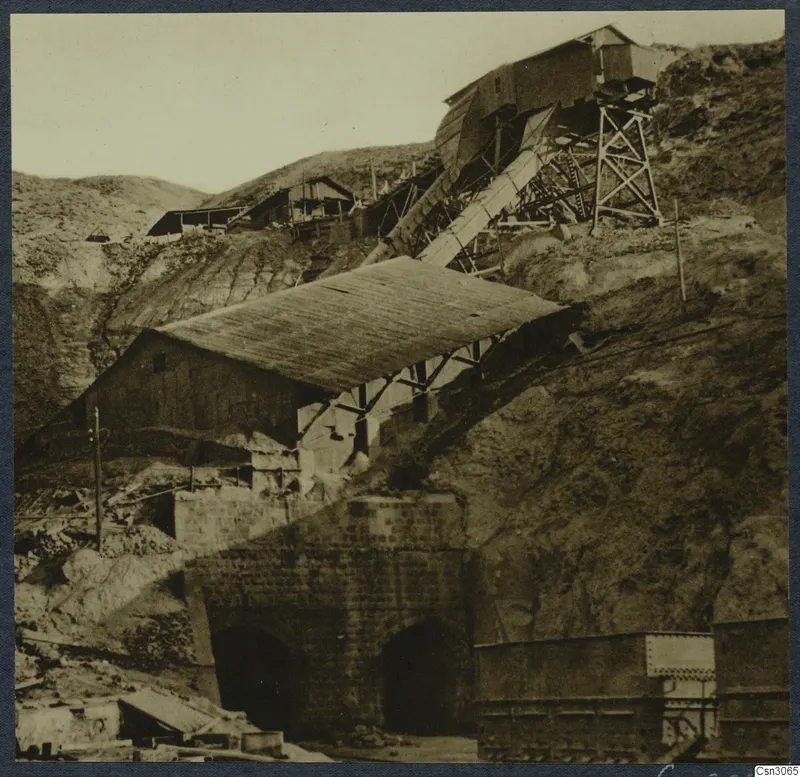 Skouriotissa copper mine: sheds, a sloping chute and arched tunnel entrances on a steep, bare hillside.