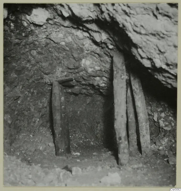 Ancient open stope at Mavrovouni, with wooden props holding up the rock and loose stones on the floor.