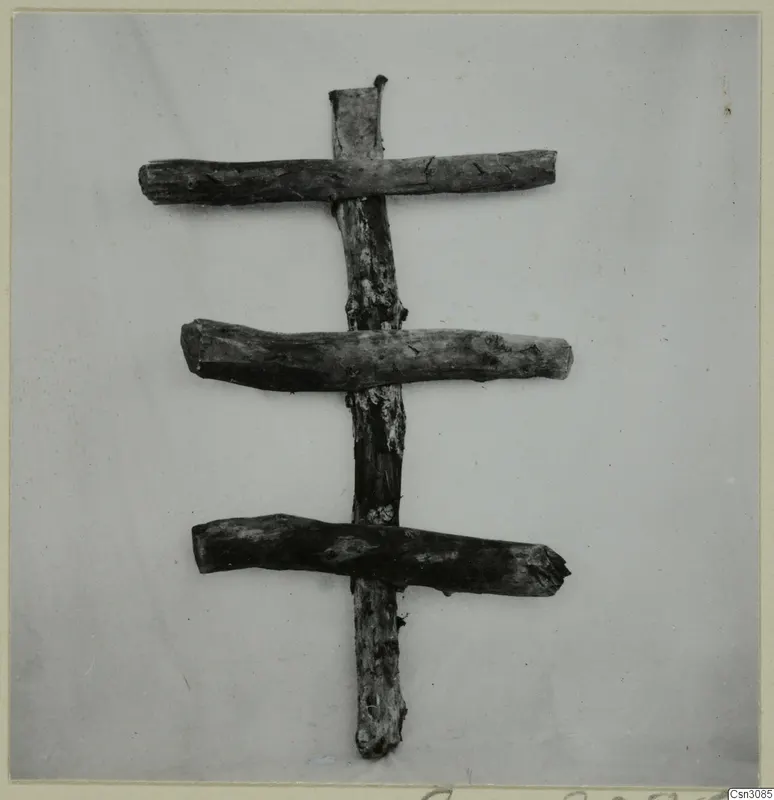 Ancient timber set: an upright post with three horizontal pieces across it, photographed against a pale background.