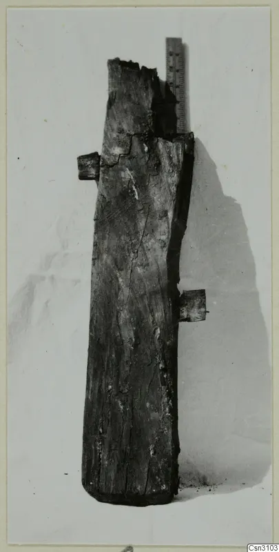 Weathered wooden timber with two short side projections, shown beside a metal ruler