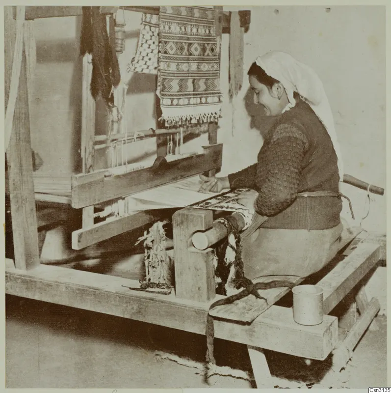Woman weaving at a wooden loom, with a patterned textile hanging above the frame.