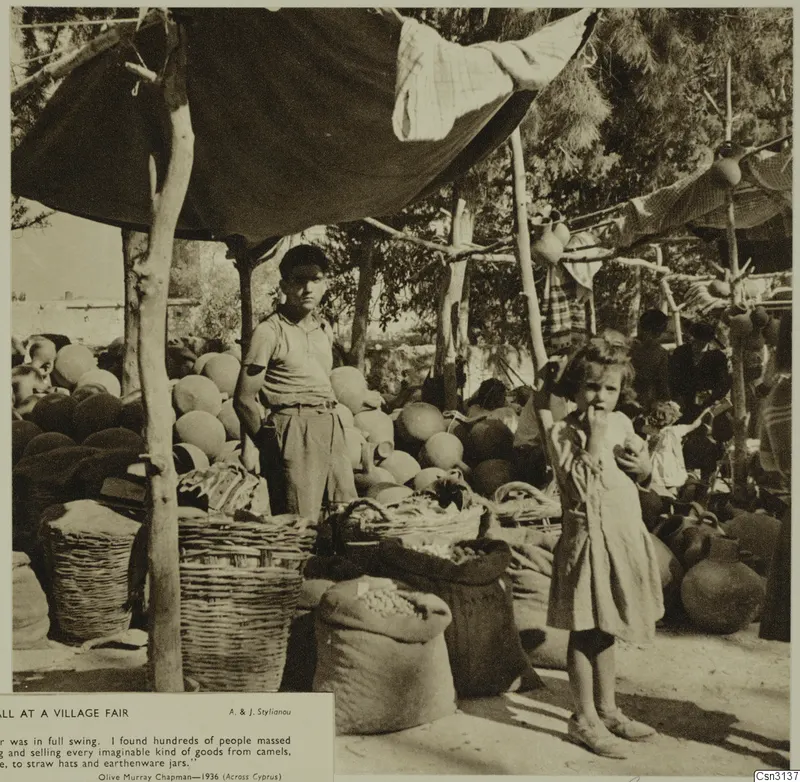 Potter's stall at a village fair: round pots, baskets and sacks under a canopy, with a boy and a small girl in front.