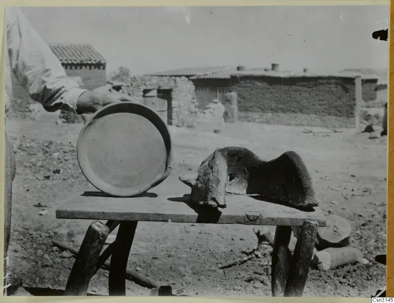 Clay dish and clay windbreak for an outdoor fire on a rough wooden table at Klirou village