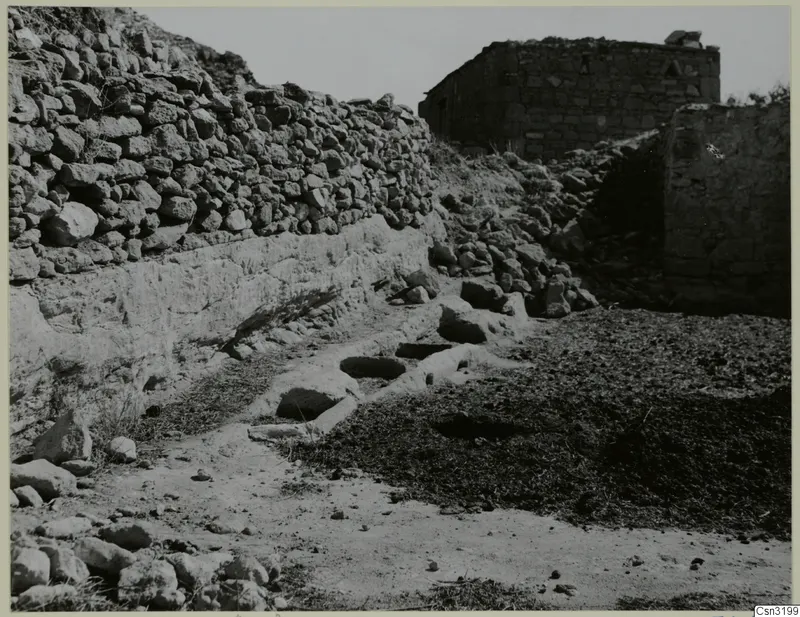 Donkey feeding place at Gallinoporni: stone troughs cut into a rock ledge beside a dry-stone wall