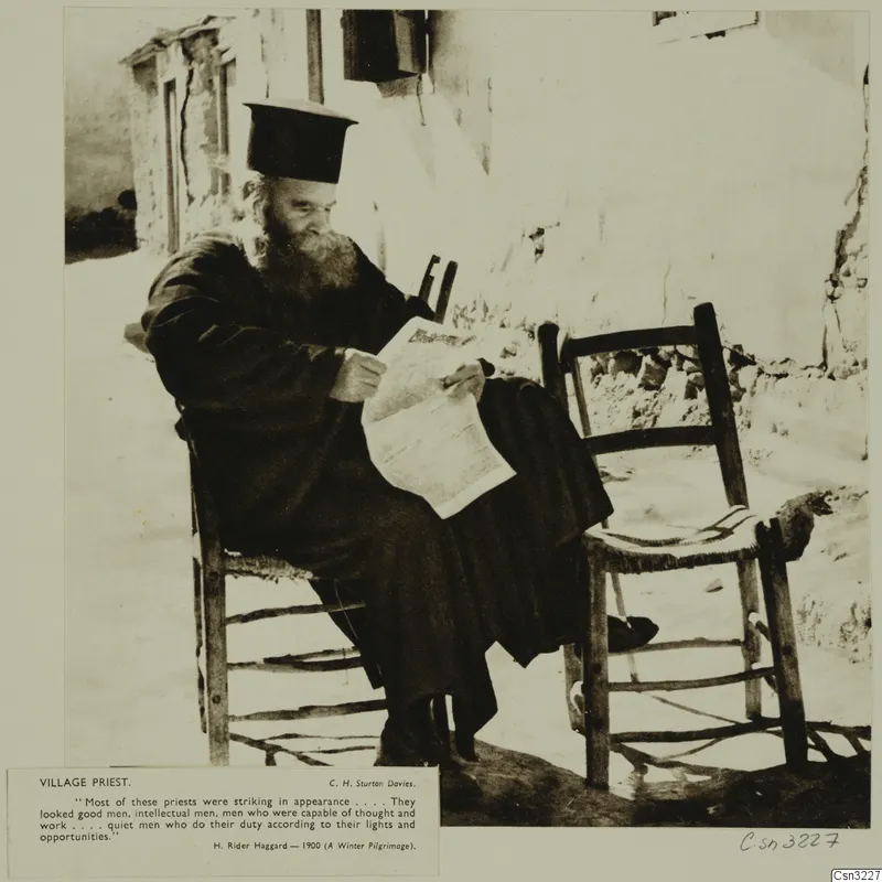 Village priest in a dark robe and tall black hat, seated on a wooden chair and reading a printed sheet beside a whitewashed wall.