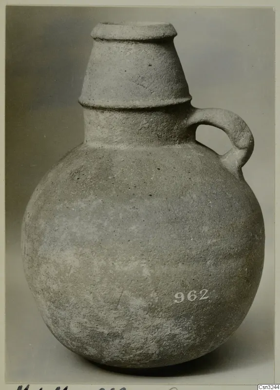 Pottery Plain White IV-V vessel with a round body, tall tapering neck with raised bands, and a single strap handle
